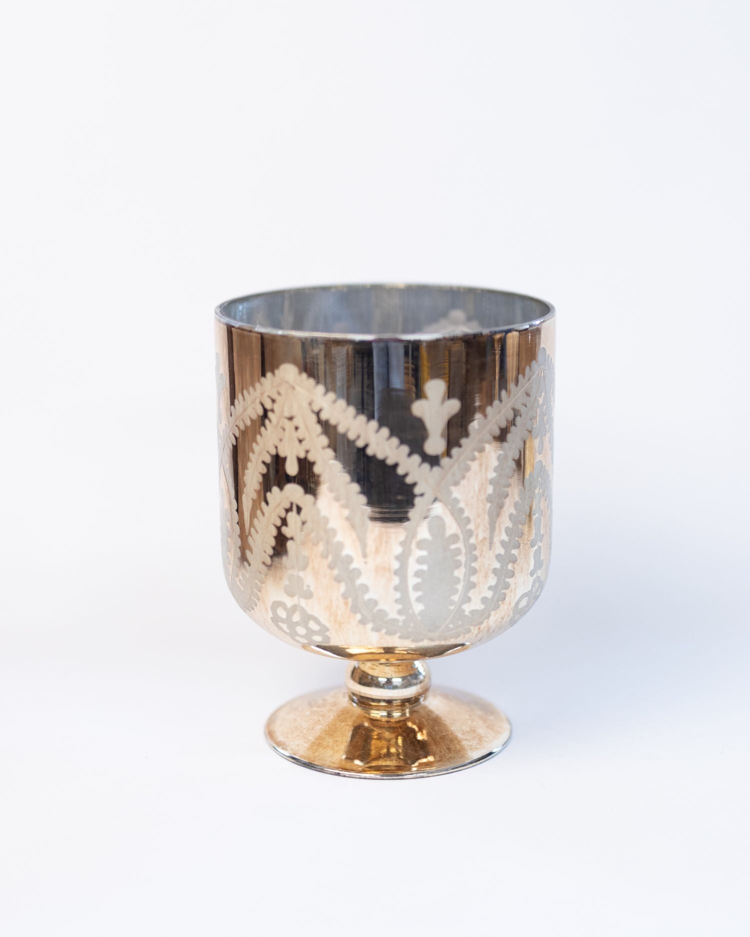 Decorative glass with gold and silver design on a white background