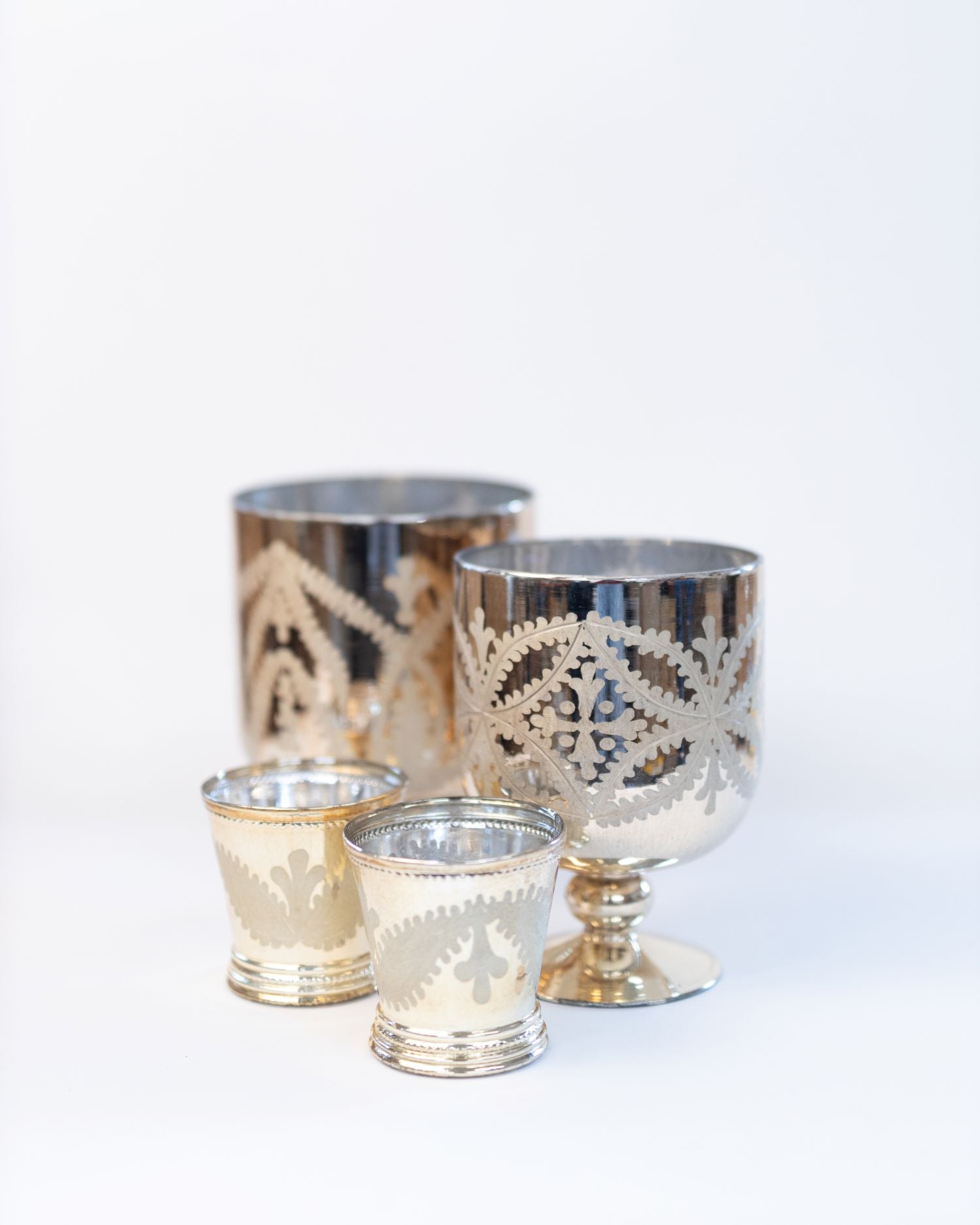 Set of silver decorative candle holders on a white background