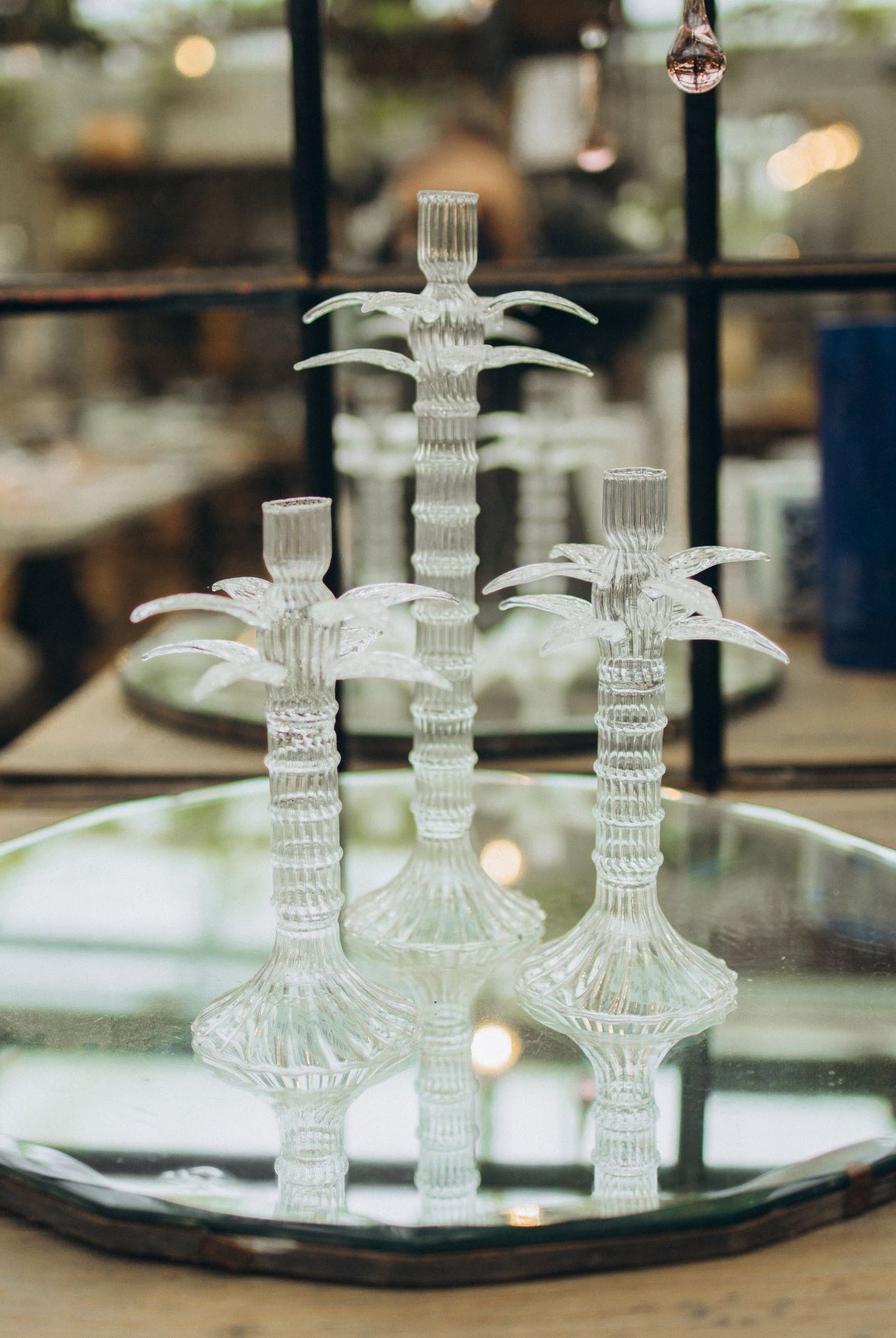 Decorative glass candelabra on a reflective surface with a blurred indoor background