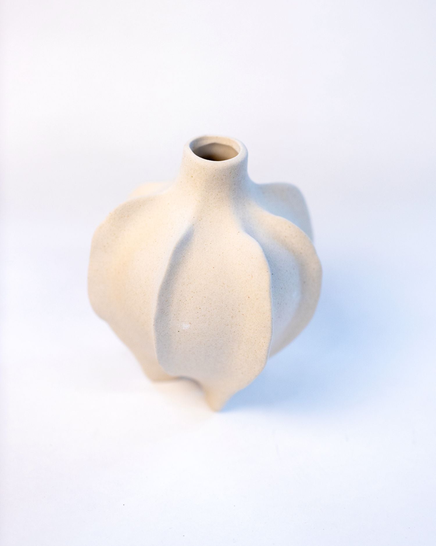 White ceramic vase with a wavy design on a light background