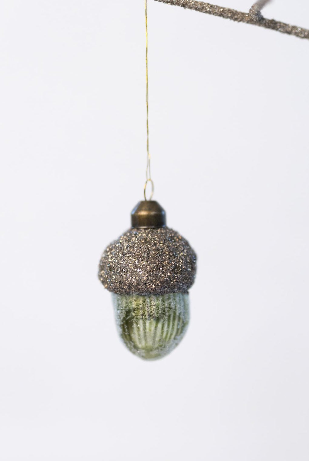 Decorative acorn ornament with glittery top on a white background