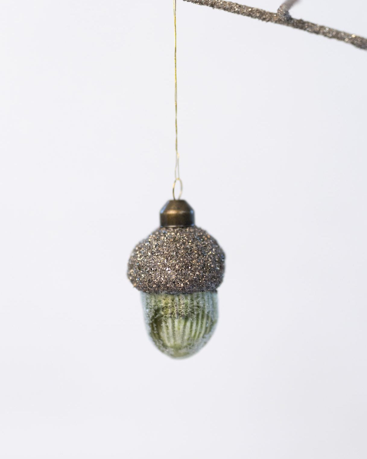 Decorative acorn ornament with glittery top on a white background