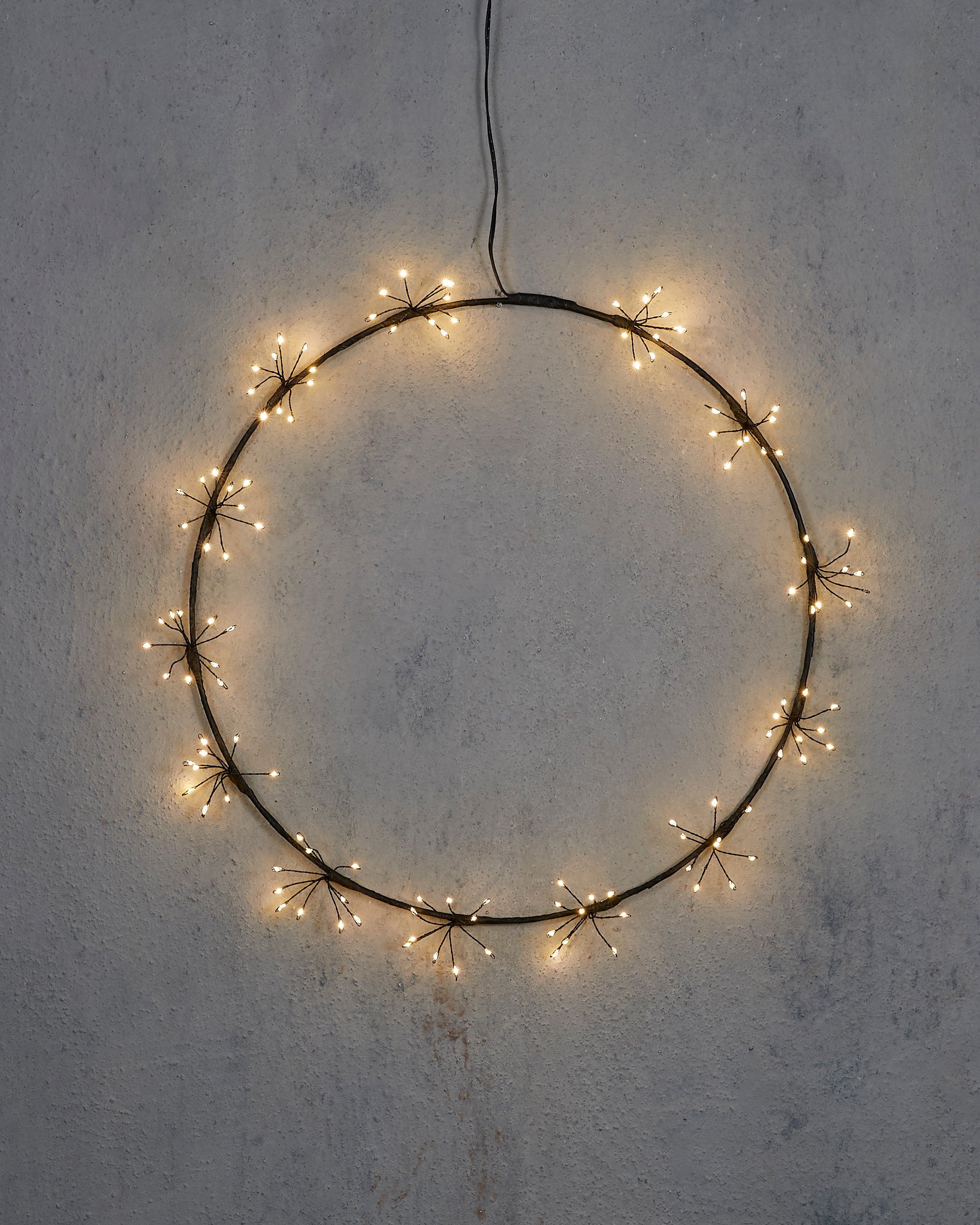 Circular string light decoration on a textured wall