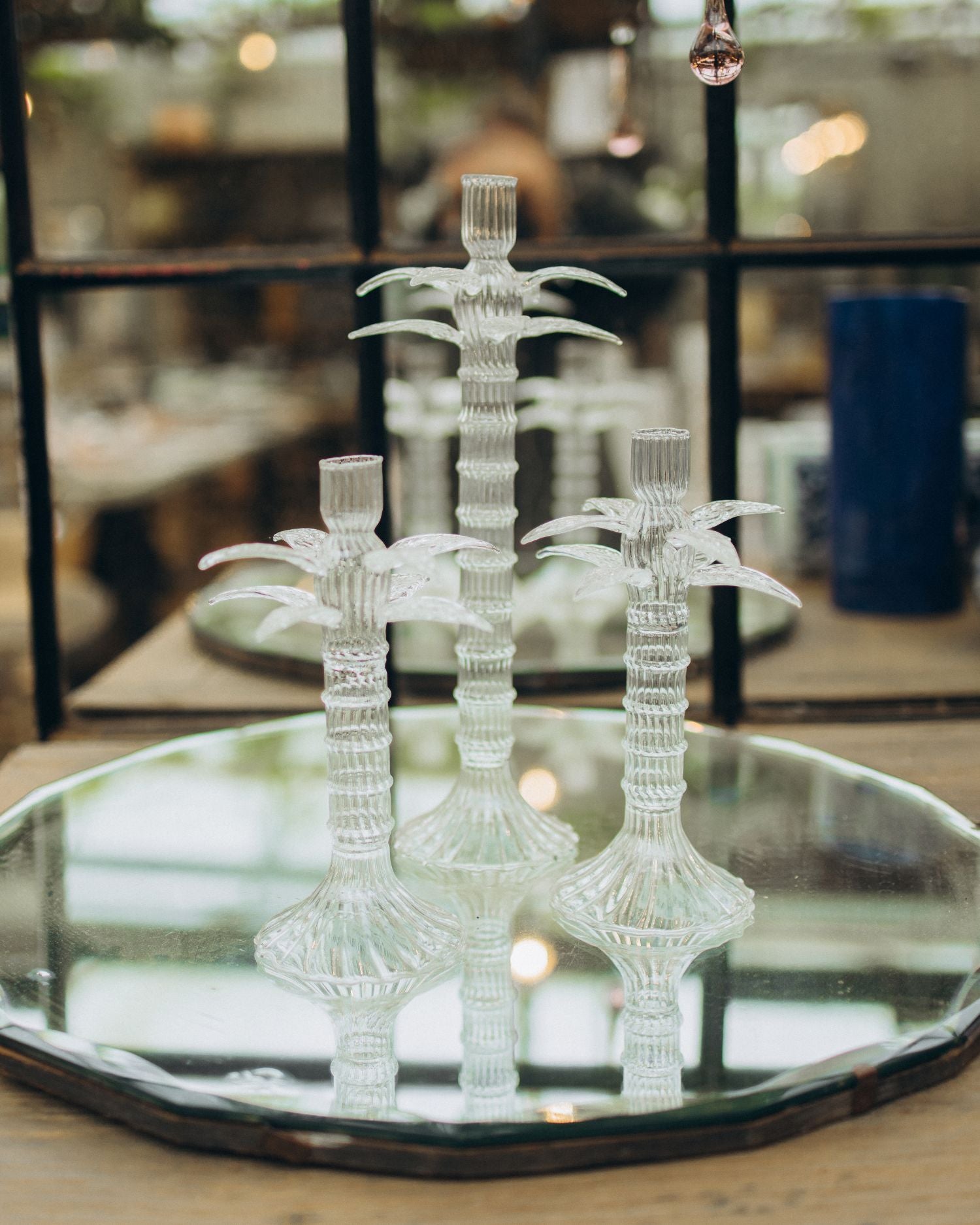Decorative glass candelabra on a reflective surface with a blurred indoor background