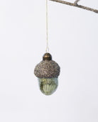 Decorative acorn ornament with glittery top on a white background